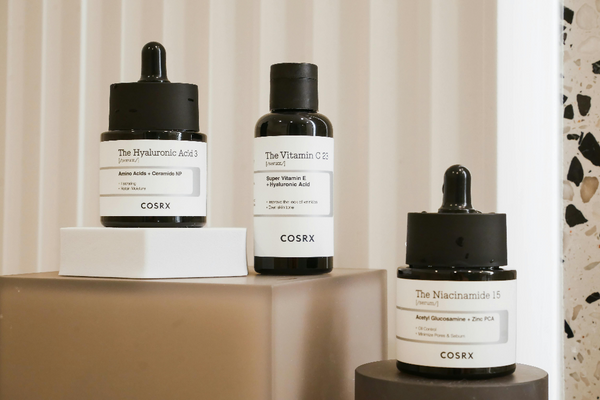 a trio of Cosrx products against a neutral background