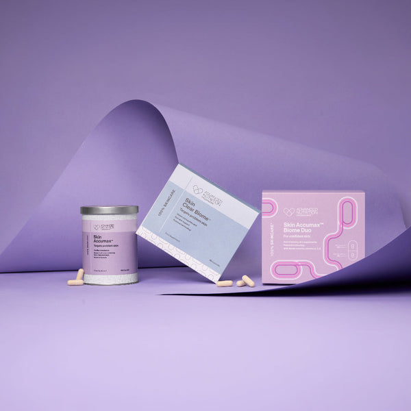 A skincare product set on a lavender studio background, featuring a white jar with a silver lid, a light blue box labeled 'Hair Growth Serum', and a pink box labeled 'Hair Growth Treatment Kit'.