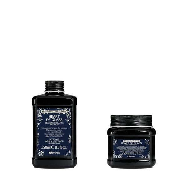 Two black cosmetic containers from the brand divinas, featuring the 'Heart of Glass' skincare line: a 250ml pump bottle on the left and a 250ml jar on the right, both with navy blue labels and white floral accents, set against a plain white background.