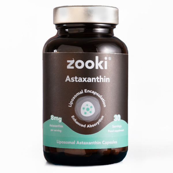 A bottle of Zooki Astaxanthin dietary supplement capsules. The product is in a dark amber brown bottle with a metallic silver cap and a dark brown label featuring a teal accent band and white text.