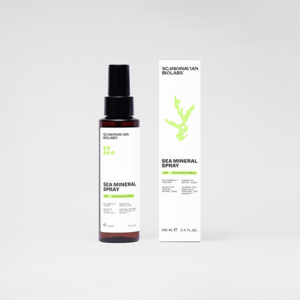 A bottle of Scandinavian Biolabs Sea Mineral Spray next to its white packaging box, featuring a minimalist green coral graphic and black text, set against a clean light gray background.
