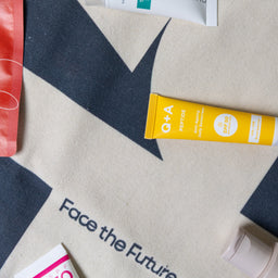 Sunscreen tube on a branded fabric with 'Face the Future' text