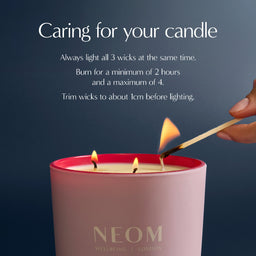 Candle being lit with NEOM branding and care instructions on a dark background
