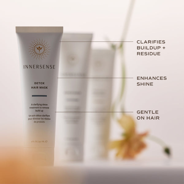 InnerSense Detox Hair Mask tube in a soft beige and white color, shown with feature callout lines and text on a warm, blurred background.