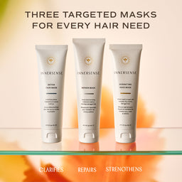 Three Innersense targeted hair masks in white squeeze tubes are displayed on a glass shelf against a warm beige and orange gradient background. The top text reads 'THREE TARGETED MASKS FOR EVERY HAIR NEED' and the bottom text lists the mask types: 'CLARIFIES', 'REPAIRS', and 'STRENGTHENS'.