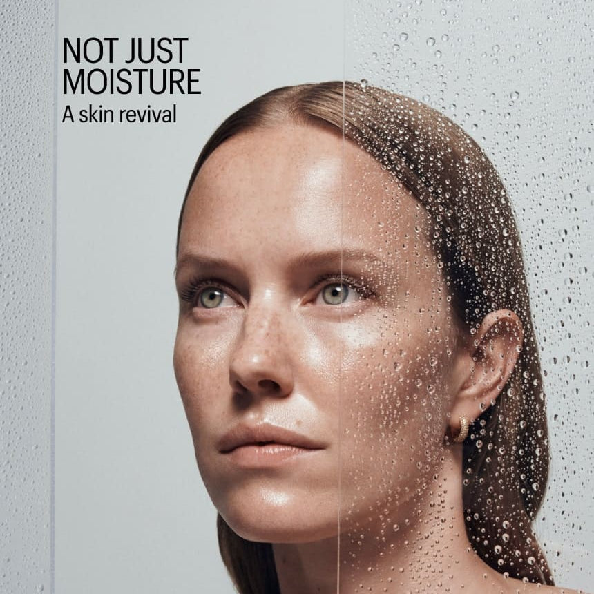 Woman with moisturized skin and water droplets, with text 'Not Just Moisture: A skin revival' on a gray background.