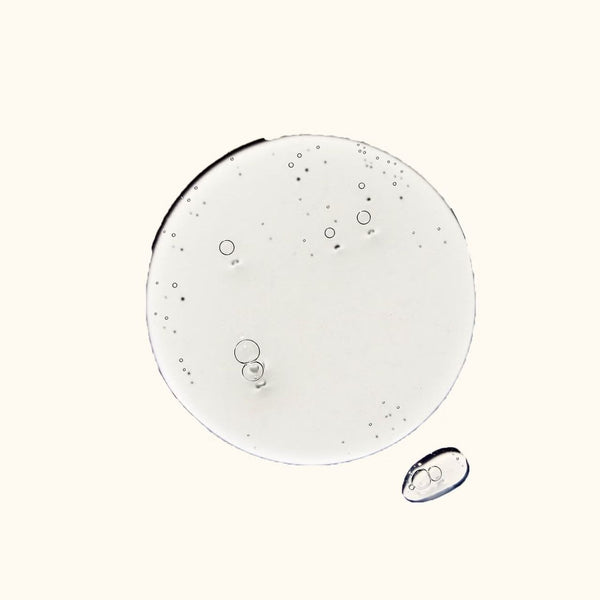 Close-up of clear liquid droplets on a white background