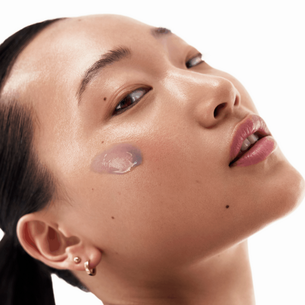 Close-up of a person with a minimal makeup look on a white background