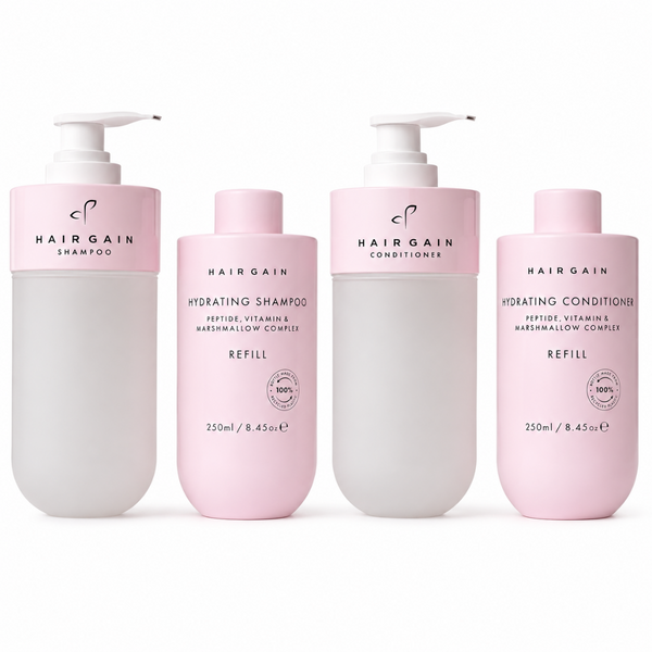 Four Hairgain hair care refill bottles in a set of shampoo, conditioner, and two hydrating conditioners, arranged on a clean white background.