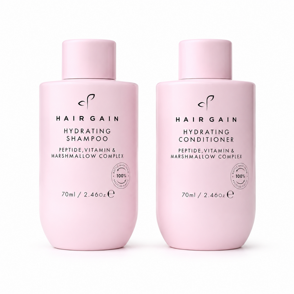 Two light pink bottles of Hairgain haircare products on a white background: Hydrating Shampoo and Hydrating Conditioner, 70ml each.