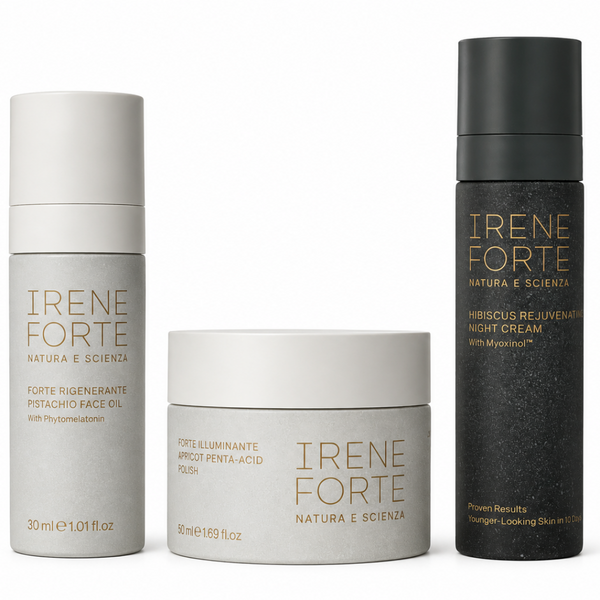 Three skincare products from Irene Forte are arranged against a plain white background: a tall white bottle on the left, a short white jar in the center, and a tall black bottle on the right. Each container has gold lettering and is photographed cleanly with soft shadows.