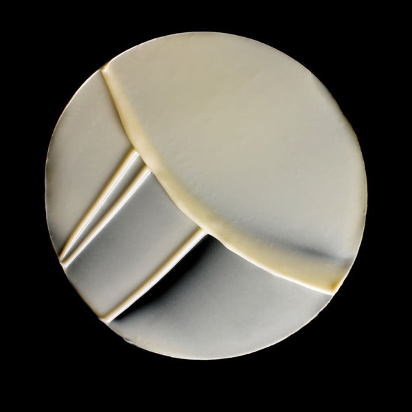 A circular beige adhesive patch with diagonal and curved cut lines, shown against a solid black background.