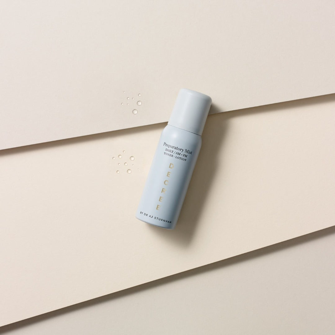 Decree Preparatory Mist with drops of texture next to the bottle