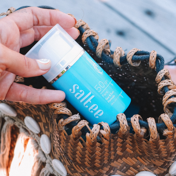 a bottle of Saltee SPF50 Face Sea & Sun Formula being taken out of a wicker bag