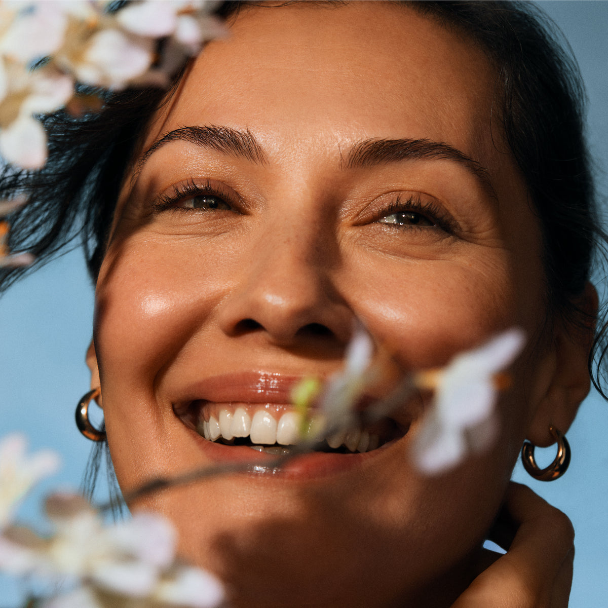 Woman smiling with a clear blue sky background