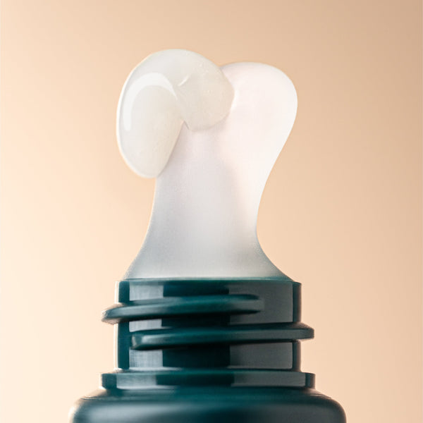 Close-up of a teal bottle with a white cap on a beige background