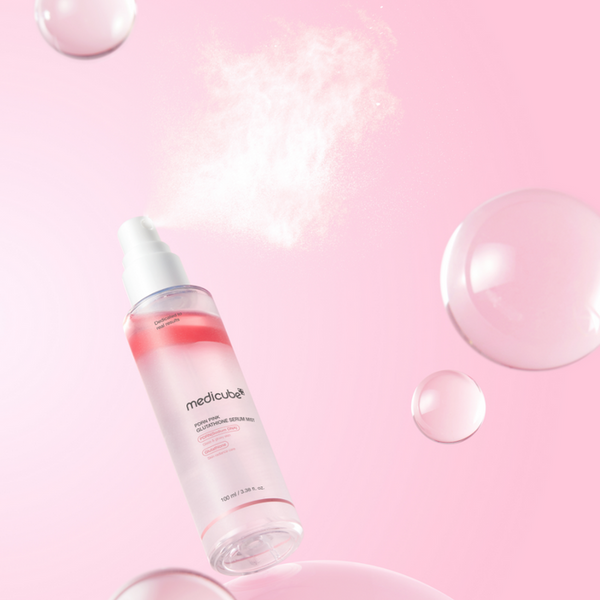 Skincare serum bottle with bubbles on a pink background