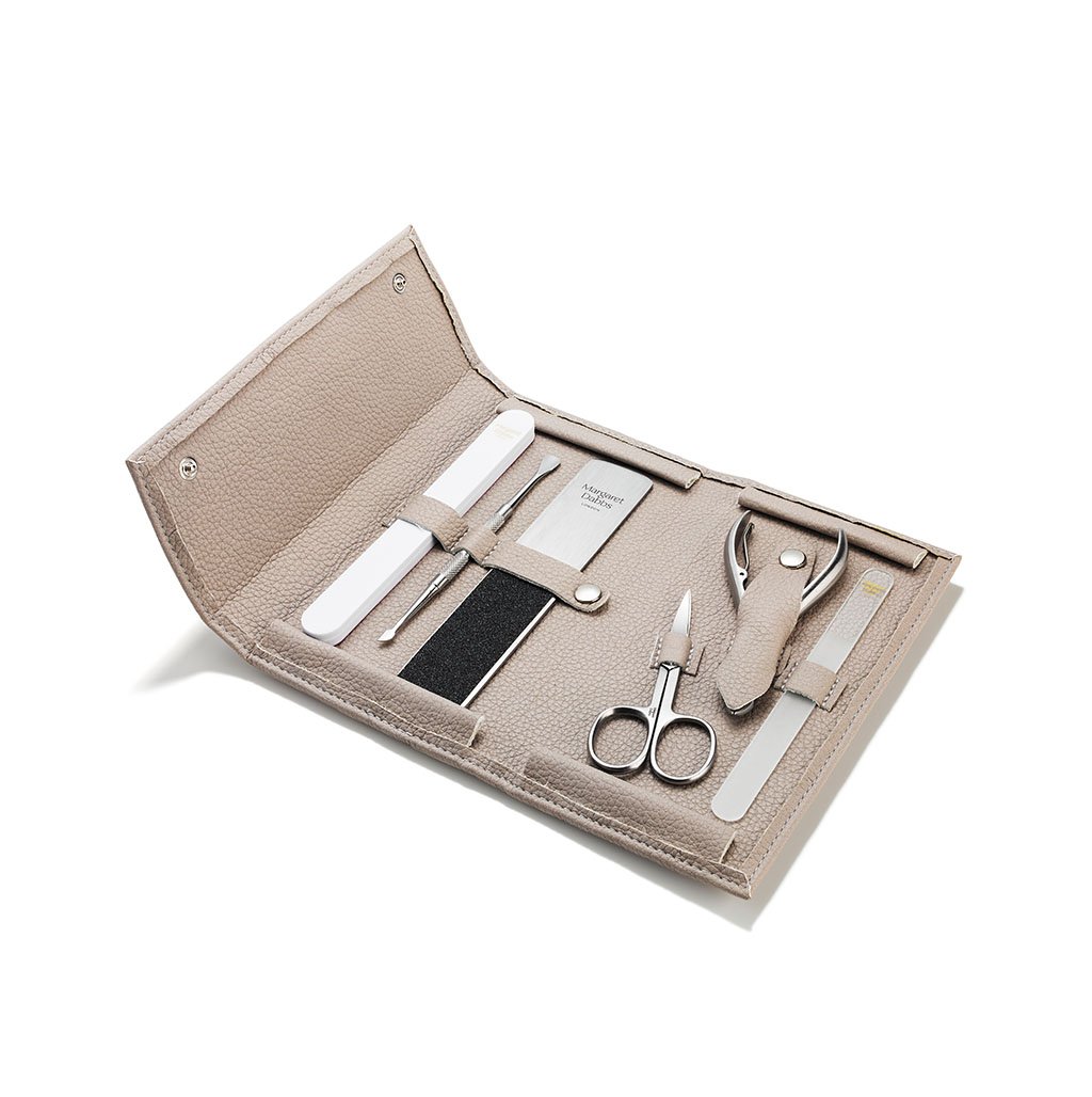 Manicure set with tools in a beige case on a white background