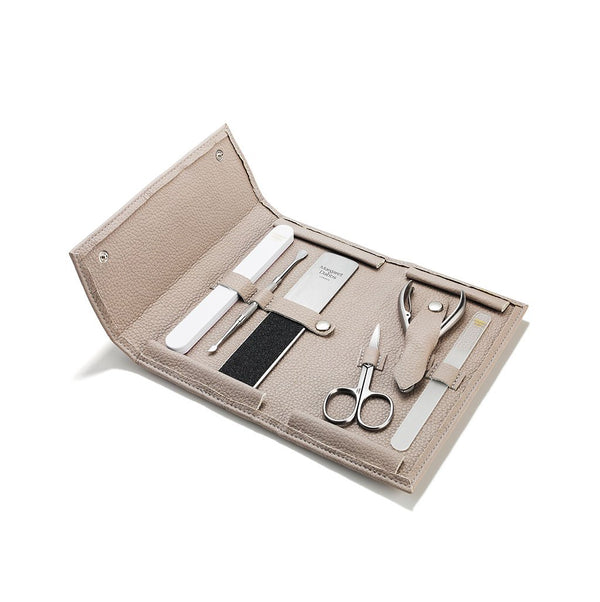 Manicure set with tools in a beige case on a white background
