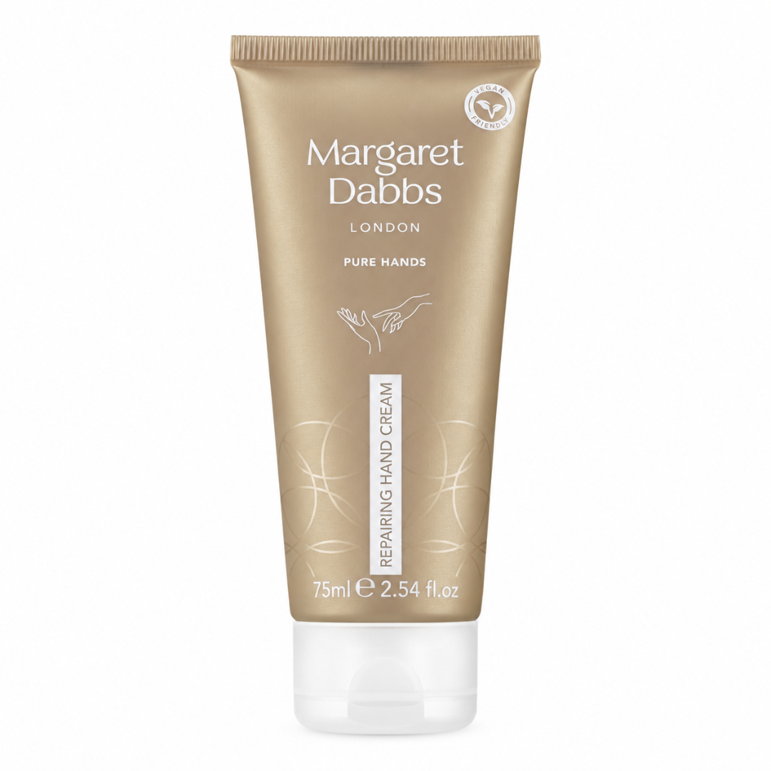 A squeeze tube of Margaret Dabbs London Pure Hands Repairing Hand Cream in a metallic gold color with a clear cap, shown on a white background.