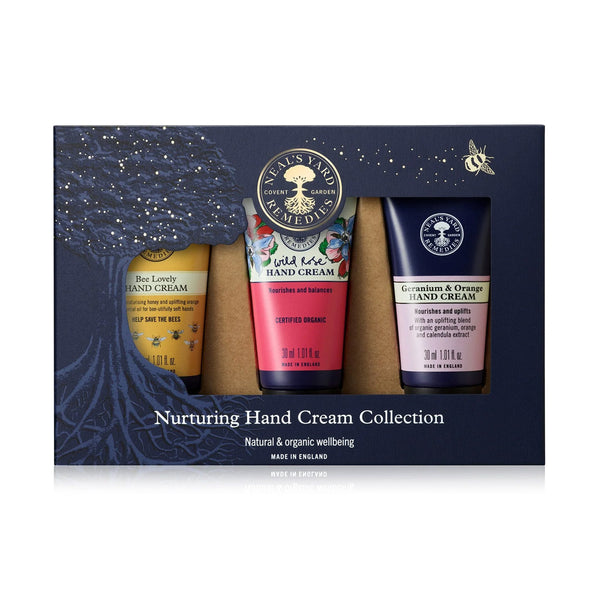 Three hand creams in a box with a decorative design and branding on a white background