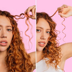 Woman with curly hair holding a strand against a pink background