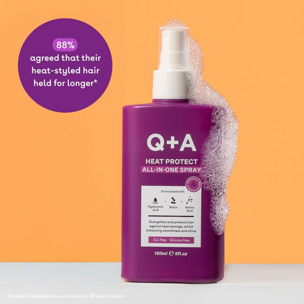 Q+A Heat Protect All-in-One Spray bottle with purple label on an orange background