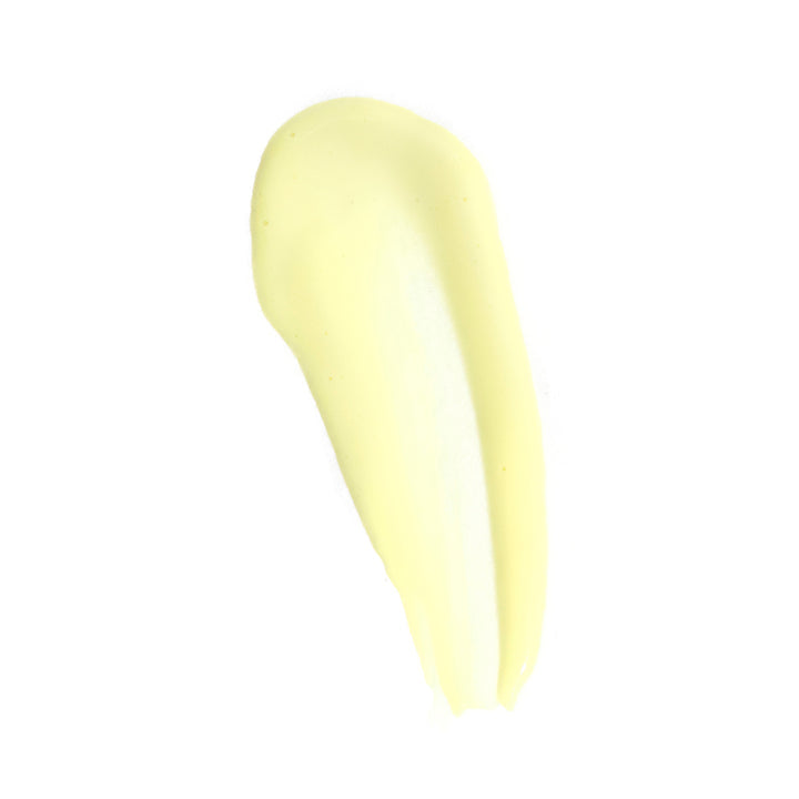 A thick, smooth smear of pale yellow cream or lotion on a solid white background.