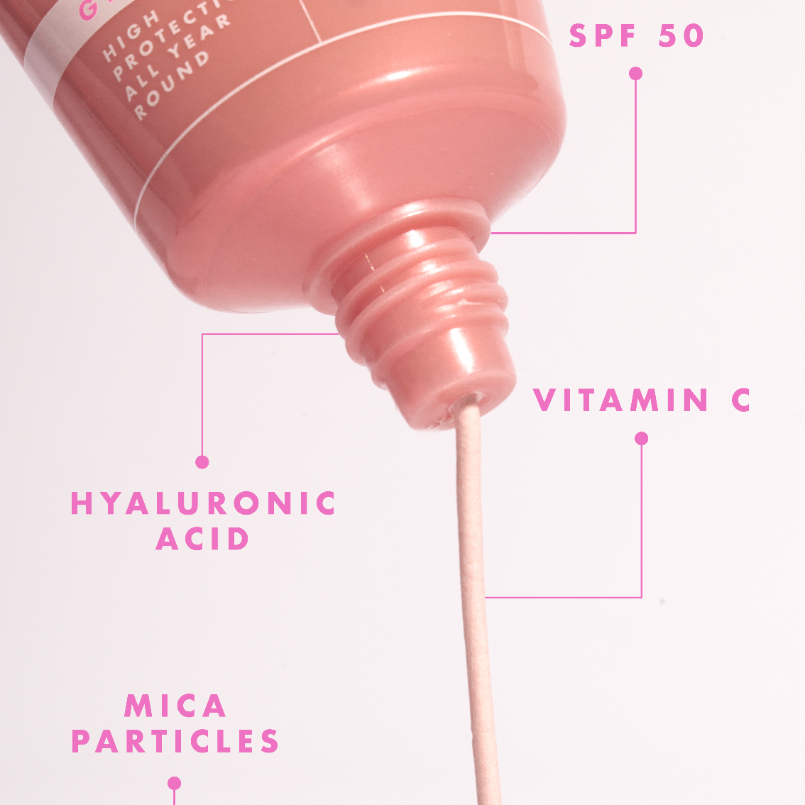 Pink skincare serum bottle with text highlighting ingredients on a white background