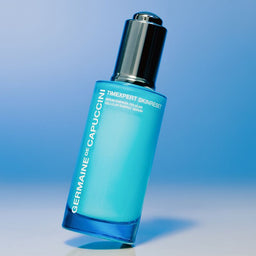 Blue skincare bottle with silver cap on a gradient blue background