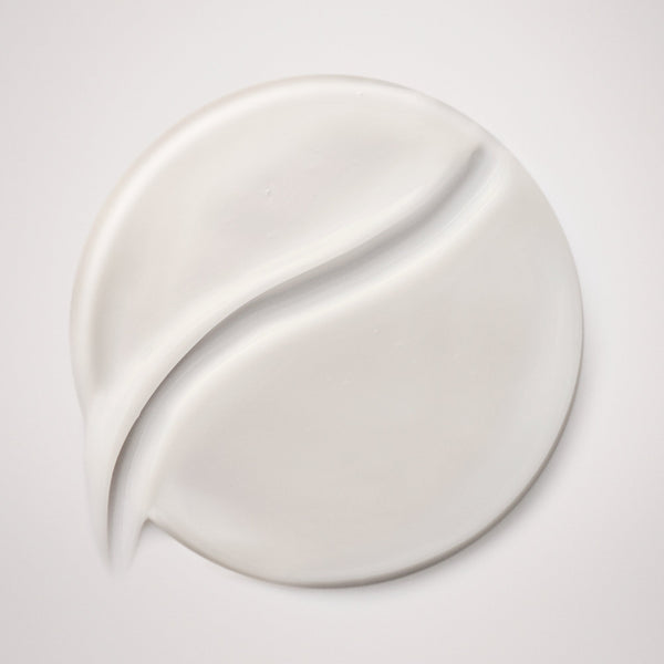 White cream smear on a light gray background