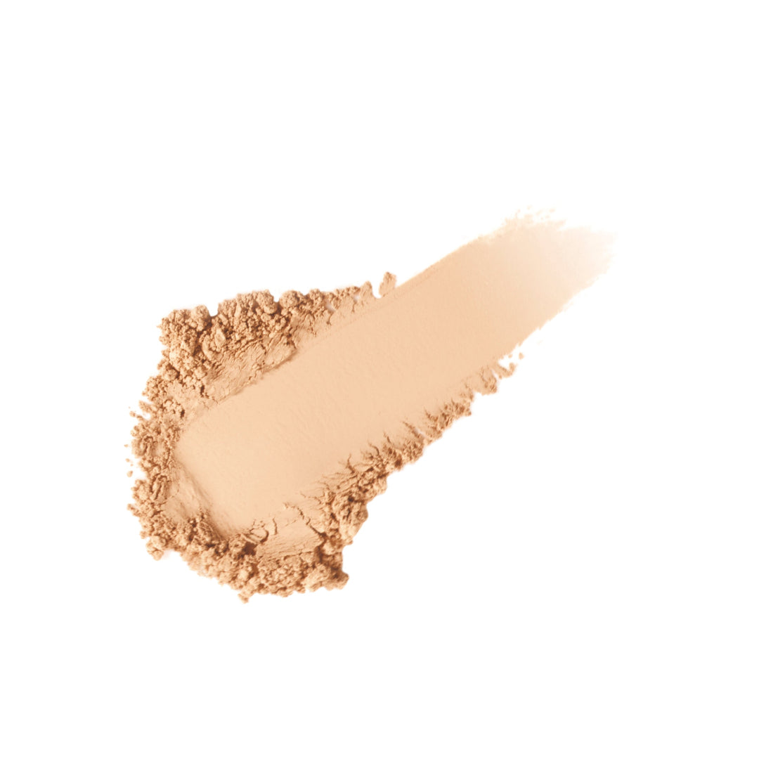 Beige makeup powder on a wooden applicator against a white background