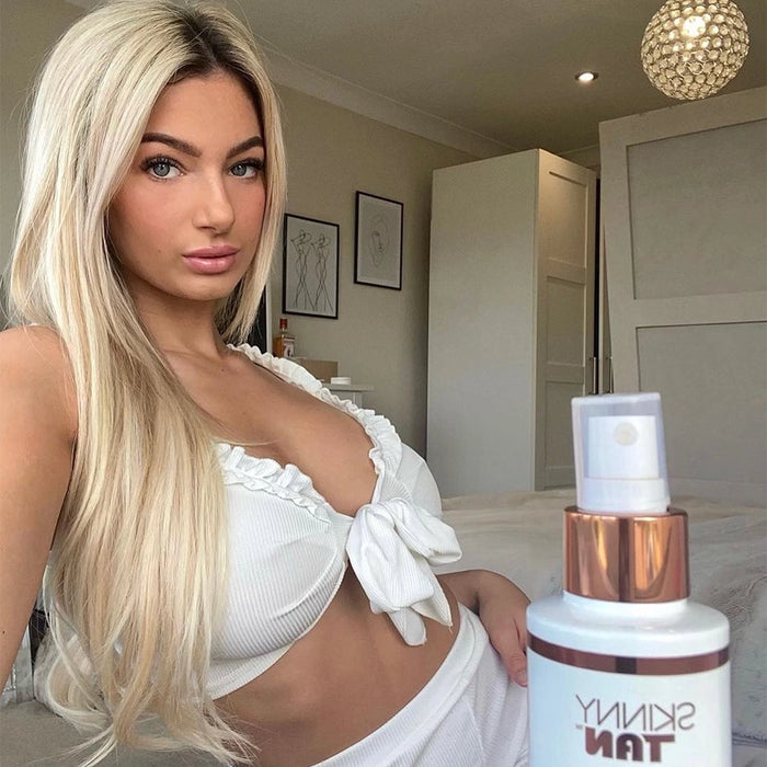 a woman sat next to a bottle of Skinny Tan Tan & Tone Self-Tanning Oil Dark