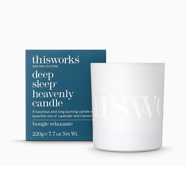 White candle with 'thisworks' branding next to its packaging on a white background