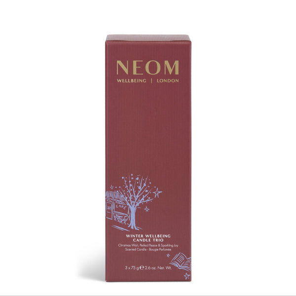 NEOM Wellbeing London Winter Wellbeing Candle Free box in a deep burgundy color with gold and white text and illustration, set against a plain white background.