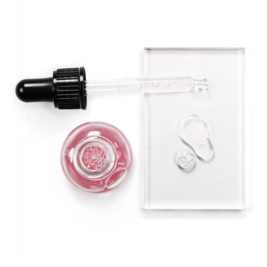 Avant Skincare Age Prestige Antioxidising & Detoxifying Rose Serum with no lid and its contents poured onto a glass slate