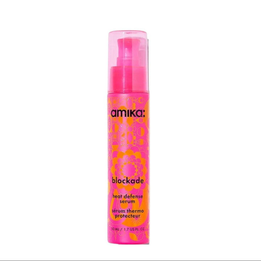 Pink bottle of amika blockade heat defense serum on a white background
