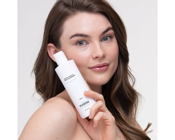 a model holding the lotion bottle close to her face