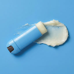 Blue lip balm with white cream on a blue background
