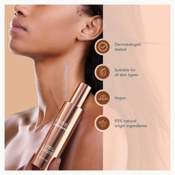 A woman in profile holds a rose gold cosmetic bottle against her neck. The right side of the image has a peach background with four brown circular icons and text reading Dermatologist tested, Suitable for all skin types, Vegan, and 93% natural origin ingredients.