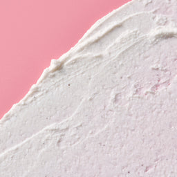 Close-up of a textured white surface with a pink background