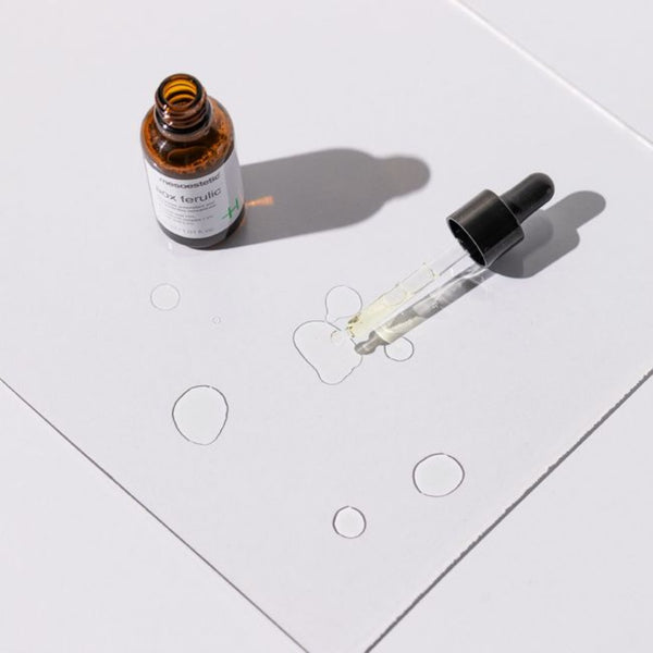 An open container of mesoestetic AOX Ferulic with its contents dropped on a glass slate