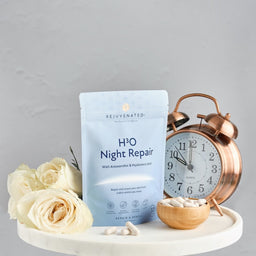 Rejuvenated H3O Night Repair packet with a small cup of capsules and clock