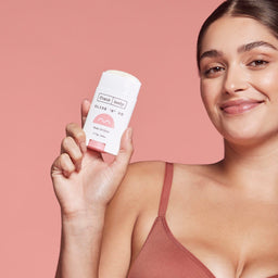 a women holding a stick of Frank Body Glide 'N' Go Body Oil Stick 